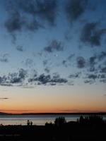 A picture of a small plane landing over Cook Inlet at sunset.